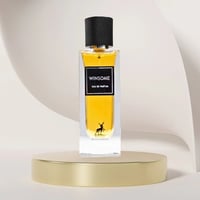 Maison Alhambra Winsome by Maison Alhambra 90ml EDP — Botol minyak wangi kaca jernih berisi cecair keemasan, penutup hitam, dan logo siluet rusa, dipamerkan di atas podium emas berlatar belakang kelabu melengkung.