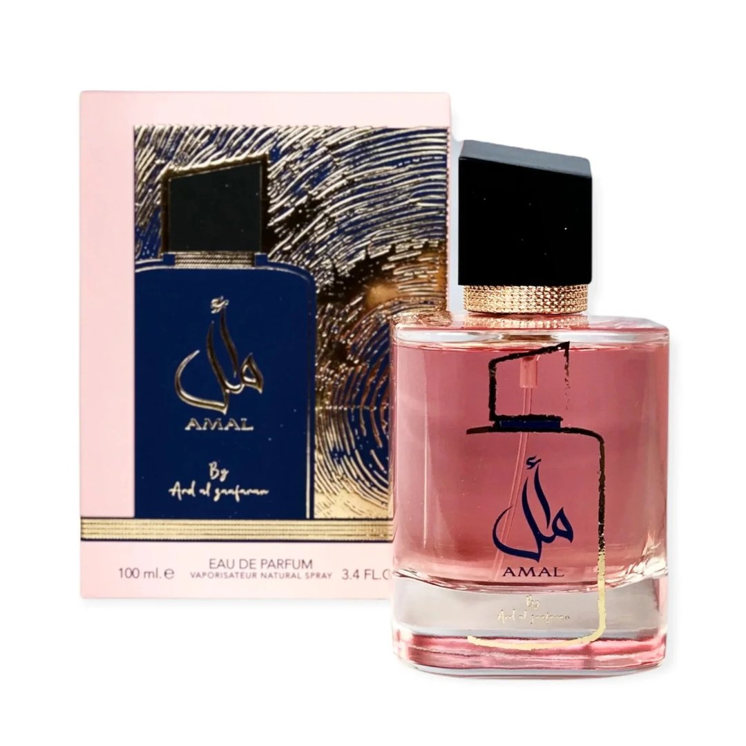Ard Al Zaafaran Amal Ard Al Zaafaran 100ml Wanita — Botol minyak wangi merah jambu dengan perincian emas dan kaligrafi Arab, bersebelahan kotak merah jambu dan birunya dengan rekaan abstrak emas.