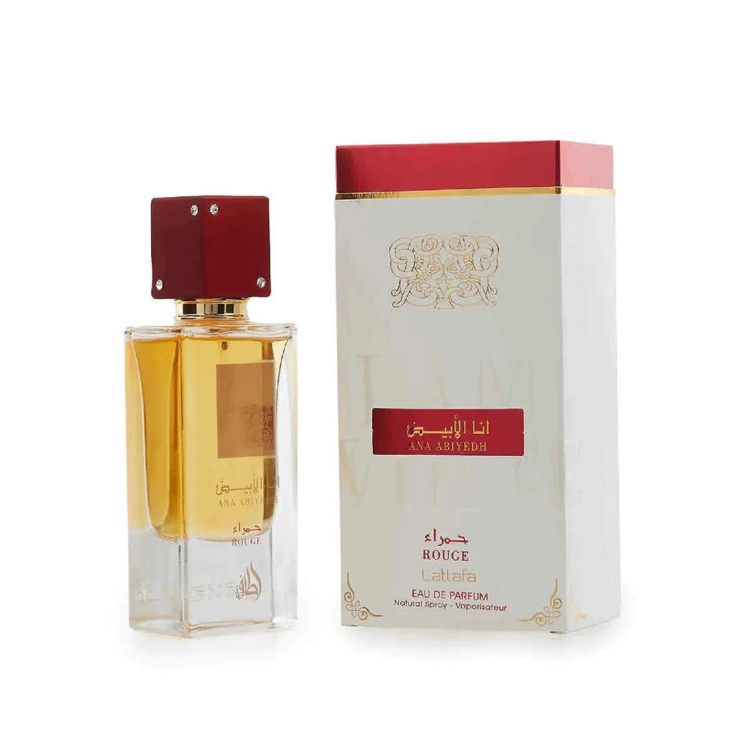 Lattafa Ana Abiyedh Rouge — Botol minyak wangi kaca jernih berisi cecair keemasan dan penutup merah bertatah permata, bersebelahan kotak segiempatnya berwarna putih dan merah dengan kaligrafi Arab emas.
