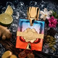 French Avenue Aromatix Teas Me 100ml — A gradient glass perfume bottle with a gold cap and emblem, surrounded by ice, lime slices, ginger, cardamom pods, vanilla beans, and amber-like crystals.