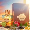 French Avenue Aromatix Teas Me — A clear glass perfume bottle with a gold geometric cap and gold label, next to its gradient box. Surrounded by ingredients like lime, tea leaves, cardamom, vanilla, and patchouli oil.