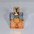 French Avenue Aromatix Teas Me — Square glass perfume bottle with gradient orange and blue liquid, gold faceted cap, and gold decorative accents on the front.