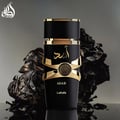 Lattafa Asad Lattafa EDP 100ml Men — Botol minyak wangi hitam dengan perincian emas dan tulisan Arab, berlatar belakang gelap bertekstur seperti kayu terbakar atau arang.