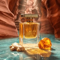 Lattafa Atlas Canyon Lattafa 55ml Unisex — Botol minyak wangi kaca jernih berisi cecair keemasan, dengan tulisan Arab dan Inggeris, terletak di atas permukaan bertekstur bersama halia dan resin seperti ambar, berlatar belakang ngarai batu pasir dan air.