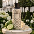Maison Asrar Belgravia by Maison Asrar Eau de Parfum — Botol Belgravia Royal Collection bersama limau bergamot, limau nipis, dan bunga putih di taman.