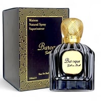 Maison Alhambra Baroque Satin Oud 100ml — A black fluted perfume bottle with a gold textured cap sits next to its matching dark blue and gold patterned box. | Maison Alhambra Baroque Satin Oud 100ml — Botol minyak wangi hitam berlekuk dengan penutup bertekstur emas duduk bersebelahan dengan kotak corak biru gelap dan