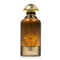 Paris Corner Daar Al Oud Intense 100ml — A clear glass perfume bottle with amber liquid, featuring a gold ornate cap and a sunburst-like design with Arabic script and 'DAAR AL OUD' text. | Paris Corner Daar Al Oud Intense 100ml — Botol minyak wangi kaca jernih dengan cecair berwarna ambar, menampilkan penutup emas