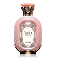 Zimaya Daiman Eden Eau De Parfum 100ml by Zimaya — A pink oval perfume bottle with a textured surface, gold accents, and a faceted pink and gold cap, set against a white background with a subtle reflection. | Zimaya Daiman Eden Eau De Parfum 100ml by Zimaya — Botol minyak wangi bujur merah jambu dengan permukaan