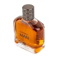 Grandeur Statement Man Eau De Parfum 100ml — Amber liquid in a clear glass bottle with a dark metallic cap, featuring the text "STATEMENT MAN" and a logo on the front. | Grandeur Statement Man Eau De Parfum 100ml — Cecair berwarna ambar dalam botol kaca jernih dengan penutup logam gelap, menampilkan teks "STATEMENT