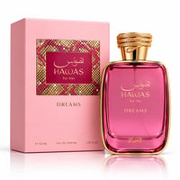 RASASI Hawas Dreams by Rasasi 100ml EDP — Botol minyak wangi merah jambu dengan penutup emas ala ular dan kotak merah jambu sepadan dengan sisipan corak emas dan merah, dipamerkan di latar belakang putih.