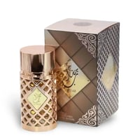 Ard Al Zaafaran Jazzab Gold by Ard Al Zaafaran Eau De Parfum 100ml — Botol wangian emas bertekstur jaring berlian dengan penutup berkilat, diletakkan di sebelah kotak wangian yang sepadan dengan corak berlian dan hiasan berpilin emas.