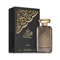 Lattafa Musk Al Aroos by Lattafa 80ml EDP — A black perfume box with gold ornate cutouts and Arabic calligraphy sits next to a rectangular glass perfume bottle with a gold cap, also featuring Arabic calligraphy and ornate gold details. | Lattafa Musk Al Aroos by Lattafa 80ml EDP — Kotak minyak wangi hitam dengan