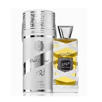 Lattafa Oud Mood Reminiscence — Kotak silinder perak tinggi berdiri sebelah botol minyak wangi kaca jernih berisi cecair kuning. Kotak ada corak perak berukir dan botol dibalut reben putih.