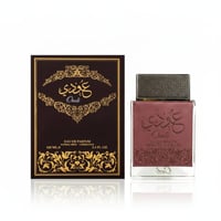 Ard Al Zaafaran Oudi – Brown box with gold Arabic script and ornate pattern next to a maroon leather-accented glass bottle