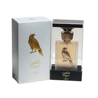 Lattafa Pride Shaheen Gold by Lattafa Perfumes Unisex 100 ml — A white box with a gold falcon illustration stands next to a clear-cased perfume bottle featuring a gold falcon emblem and gold cap.