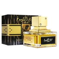 Lattafa Sheikh Al Shuyukh Concentrated by Lattafa 100ml — Botol minyak wangi kaca jernih dengan perincian emas dan penutup emas, diletakkan di sebelah kotak bercorak hitam dan emasnya dengan tulisan Arab.