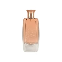 Maison Alhambra Glossy By Maison Alhambra 100ml Women EDP — A tall, clear glass perfume bottle with a rose gold cap, filled with a light peachy-pink liquid. The word "GLOSSY" is embossed vertically on the front, with a deer silhouette and "MAISON A. ALHAMBRA" below.