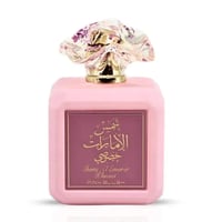 Ard Al Zaafaran Shams Al Emarat Khususi Pink Blush 100ml — Pink perfume bottle with a decorative floral-patterned clear glass cap and gold accents, featuring a maroon label with Arabic and English text.