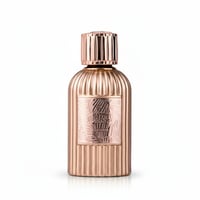 Paris Corner Qissa Delicious by Paris Corner – 100 ml for Women, a rose gold fluted perfume bottle with a textured label featuring tropical leaves.