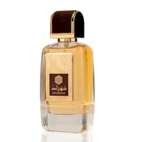 Ard Al Zaafaran Shahrazad Eau De Parfum — Botol kaca jernih berisi cecair keemasan, dengan penutup coklat baldu dan bingkai emas pada label yang tertera tulisan Arab dan 'SHAHRAZAD'