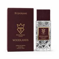 Bujairami Woodlands by Bujairami Extrait de Parfum 100ml — A maroon box and a clear, faceted glass perfume bottle with a maroon cap, both featuring gold branding and the 'B' crown logo.