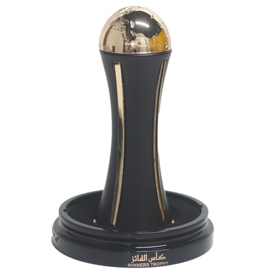 Lattafa Pride Al Khas Winners Trophy Gold 100ml — A black and gold trophy with a globe on top, set on a black base with Arabic and English text. | Lattafa Pride Al Khas Winners Trophy Gold 100ml — Piala hitam dan emas dengan globe di atasnya, diletakkan di atas tapak hitam dengan teks Arab dan Inggeris.