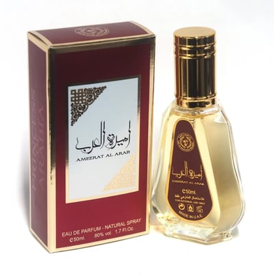 Ard Al Zaafaran Ameerat Al Arab Princess of Arabia 50ml — A maroon and gold perfume box stands next to a clear glass perfume bottle with a gold cap and maroon label. | Ard Al Zaafaran Ameerat Al Arab Princess of Arabia 50ml — Peti minyak wangi berwarna merah marun dan emas berdiri di sebelah botol minyak wangi kaca