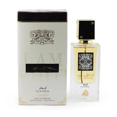 Lattafa Ana Abiyedh Leather 60ml by Lattafa Perfumes — A white perfume box with gold accents and Arabic calligraphy sits next to a clear glass perfume bottle with a gold cap and black accents, also featuring Arabic calligraphy. | Lattafa Ana Abiyedh Leather 60ml oleh Lattafa Perfumes — Kotak minyak wangi putih dengan