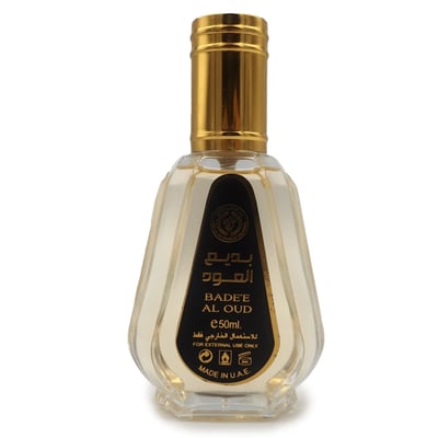 Ard Al Zaafaran Badee Al Oud Eau De Parfum 50ml — A clear glass perfume bottle with a faceted design and a gold cap, featuring a black label with Arabic and English text. | Ard Al Zaafaran Badee Al Oud Eau De Parfum 50ml — Botol minyak wangi kaca jernih dengan reka bentuk berfaset dan penutup emas, menampilkan label