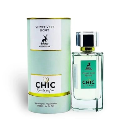 Maison Alhambra Chic Velvet Vert Secret 100ml — A cylindrical light green box with gold trim stands next to a clear glass perfume bottle with a green label and a silver and black cap. | Maison Alhambra Chic Velvet Vert Secret 100ml — Kotak silinder hijau muda dengan trim emas berdiri di sebelah botol minyak wangi kaca