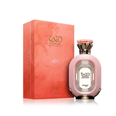 Zimaya Daiman Eden Eau De Parfum 100ml by Zimaya — A pink textured perfume bottle with gold accents sits next to its matching coral-orange textured box with gold marbling. | Zimaya Daiman Eden Eau De Parfum 100ml by Zimaya — Botol minyak wangi merah jambu bertekstur dengan aksen emas terletak di sebelah kotak