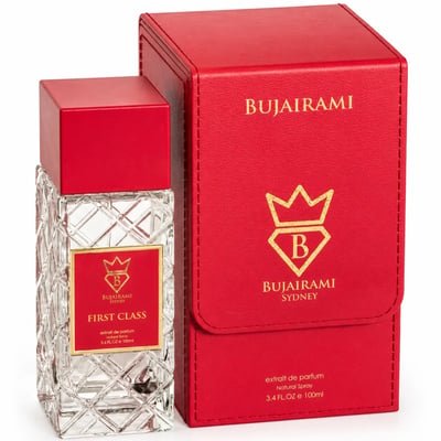 Bujairami First Class Amber Woody 100ml Extrait — Clear faceted glass perfume bottle with red cap and gold label, next to a red presentation box with gold logo.