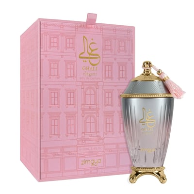 Zimaya Ghali Elegant Eau De Parfum 100ml by Zimaya — A pink box with a building facade pattern and gold Arabic calligraphy sits next to a fluted glass perfume bottle with a gold base and a pink tassel on the cap. | Zimaya Ghali Elegant Eau De Parfum 100ml oleh Zimaya — Peti merah jambu dengan corak fasad bangunan dan