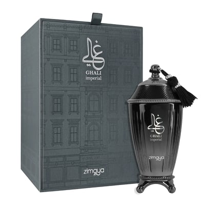 Zimaya Ghali Imperial Eau De Parfum 100ml by Zimaya — A dark grey textured box with a building facade pattern stands next to a dark, ornate perfume bottle with a tassel. | Zimaya Ghali Imperial Eau De Parfum 100ml by Zimaya — Kotak kelabu gelap bertekstur dengan corak fasad bangunan berdiri di sebelah botol minyak