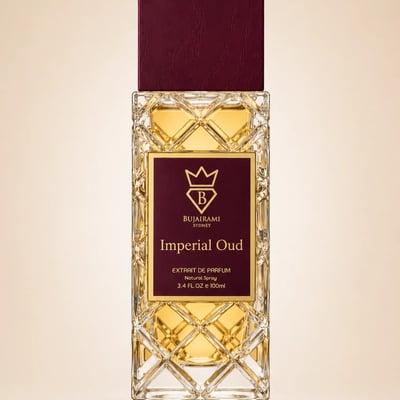 Bujairami Imperial Oud by Bujairami 100ml Extrait — Clear glass bottle with intricate geometric pattern, filled with golden liquid, topped with a deep red cap, and featuring a maroon label with gold text and a crown logo.