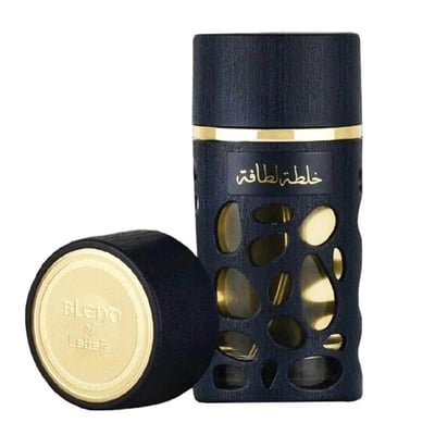Lattafa Khalta Blend Of Lattafa Eau De Parfum 100ml — A dark blue perfume bottle with a textured, cut-out design revealing gold accents, standing next to its matching dark blue cap with a gold embossed circular logo. | Lattafa Khalta Blend Of Lattafa Eau De Parfum 100ml — Botol minyak wangi biru gelap dengan reka