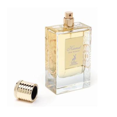 Maison Alhambra Kismet for Women 100ml by Maison Alhambra — A clear glass perfume bottle with gold accents and a gold cap lying next to it on a white background. | Maison Alhambra Kismet for Women 100ml by Maison Alhambra — Botol kaca jernih dengan perincian emas dan penutup emas terbaring di sebelahnya di atas latar