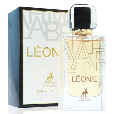 Maison Alhambra Leonie for Women by Maison Alhambra 100ml — A clear glass perfume bottle with a gold and black cap sits next to its white and black patterned box, both featuring gold lettering and a deer silhouette. | Maison Alhambra Leonie for Women by Maison Alhambra 100ml — Botol minyak wangi kaca jernih dengan
