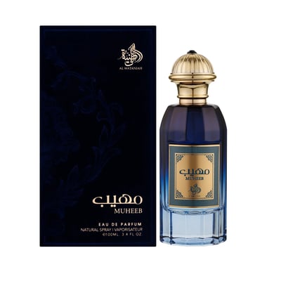 Al Wataniah Muheeb Perfume Man by Al Wataniah 100ml — A dark blue perfume bottle with a gold cap sits next to its matching dark blue box with ornate gold Arabic calligraphy and floral patterns. | Al Wataniah Muheeb Perfume Man by Al Wataniah 100ml — Botol minyak wangi biru gelap dengan penutup emas terletak di sebelah