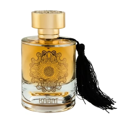 Maison Alhambra Karat by Maison Alhambra 100ml EDP — Clear glass perfume bottle with gold liquid, ornate gold emblem on the front, and a black tassel hanging from the cap.