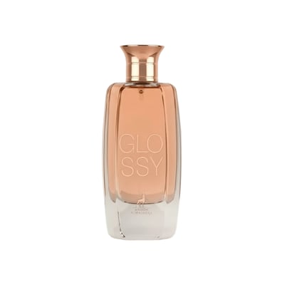 Maison Alhambra Glossy By Maison Alhambra 100ml Women EDP — A tall, clear glass perfume bottle with a rose gold cap, filled with a light peachy-pink liquid. The word "GLOSSY" is embossed vertically on the front, with a deer silhouette and "MAISON A. ALHAMBRA" below.