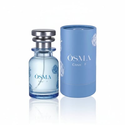 Osma Osma Citrus F 75ml Eau de Parfum - Fruity & Rose — A clear glass perfume bottle with a silver cap and blue rose accents, standing next to its matching blue cylindrical box with rose designs.