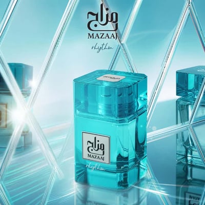 Zimaya Mazaaj Rhythm by Zimaya 100 ml EDP Unisex — A clear turquoise glass perfume bottle with a white label featuring Arabic script and 'MAZAAJ rhythm' in English, set against a reflective, diamond-patterned blue background with other bottles visible in the reflection.
