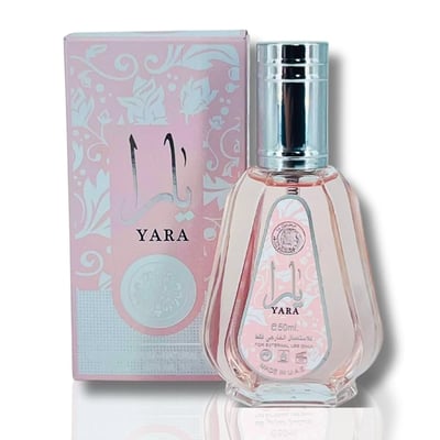 Ard Al Zaafaran Yara Eau De Parfum 50ml — Pink floral patterned box next to a pale pink faceted glass perfume bottle with a silver cap. | Ard Al Zaafaran Yara Eau De Parfum 50ml — Kotak bercorak bunga merah jambu di sebelah botol minyak wangi kaca merah jambu pucat berfaset dengan penutup perak.