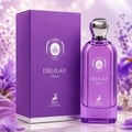 Maison Alhambra Delilah Viola 100ml — A purple perfume bottle and its matching box stand on a marble surface, surrounded by purple and white flowers. | Maison Alhambra Delilah Viola 100ml — Botol minyak wangi ungu dan kotaknya yang sepadan berdiri di atas permukaan marmar, dikelilingi bunga ungu dan putih.