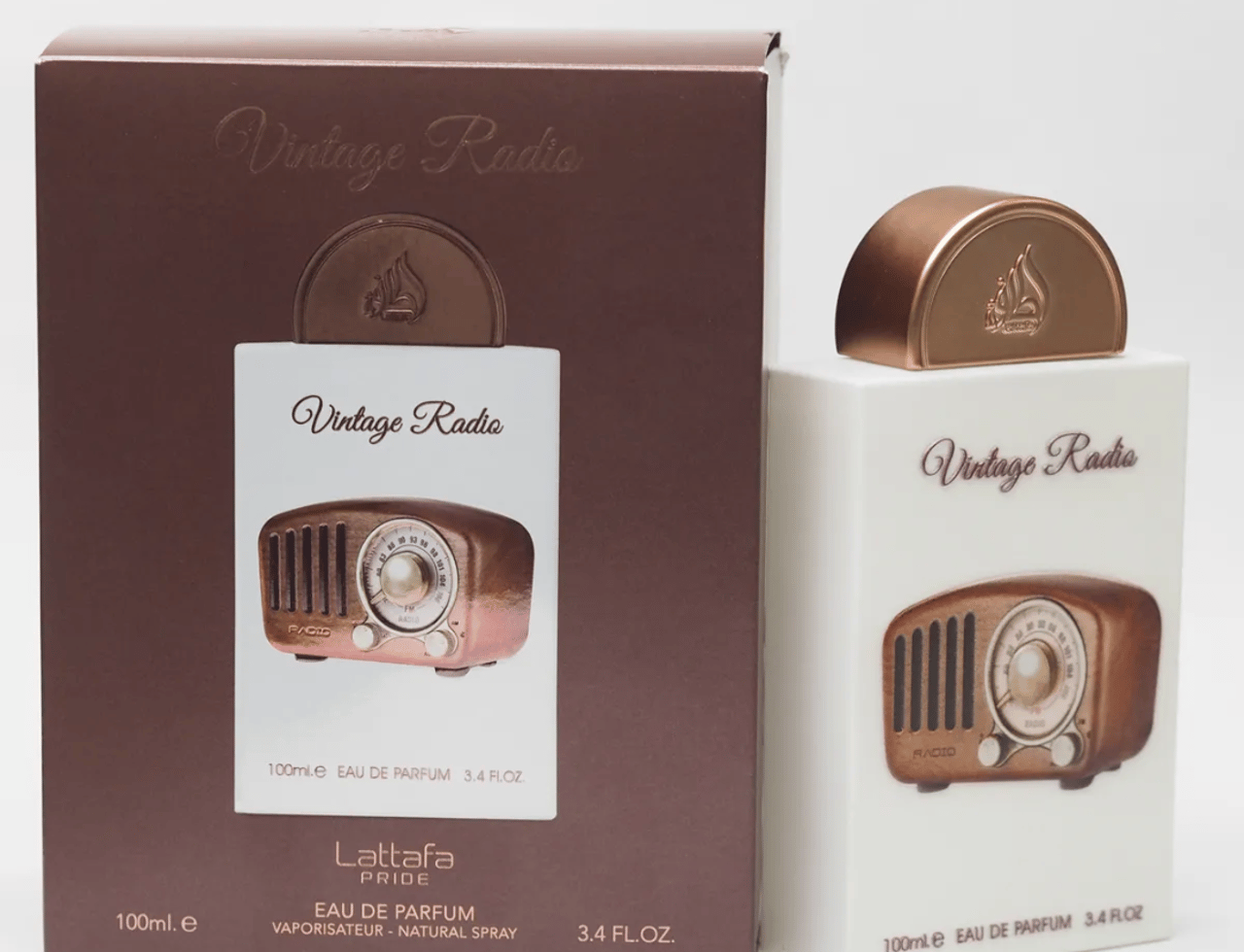 Lattafa Pride Vintage Radio — Kotak coklat dengan potongan menunjukkan kotak putih berisi botol minyak wangi radio vintaj dengan penutup tembaga.
