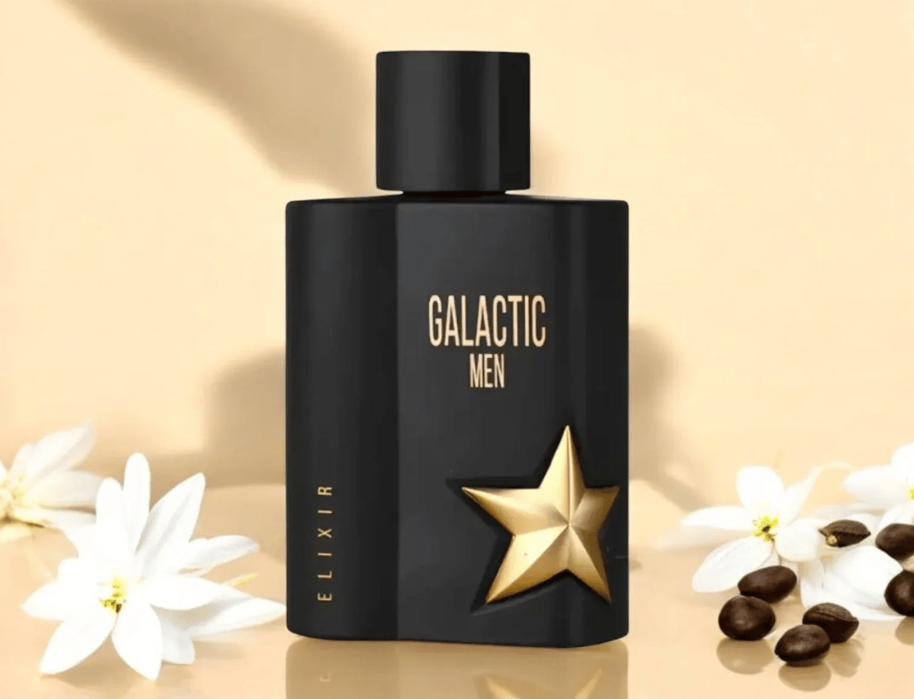 Maison Alhambra Galactic Man Elixir — Botol minyak wangi hitam dengan lambang bintang emas dan tulisan "GALACTIC MEN", dikelilingi bunga putih dan biji kopi di permukaan reflektif.