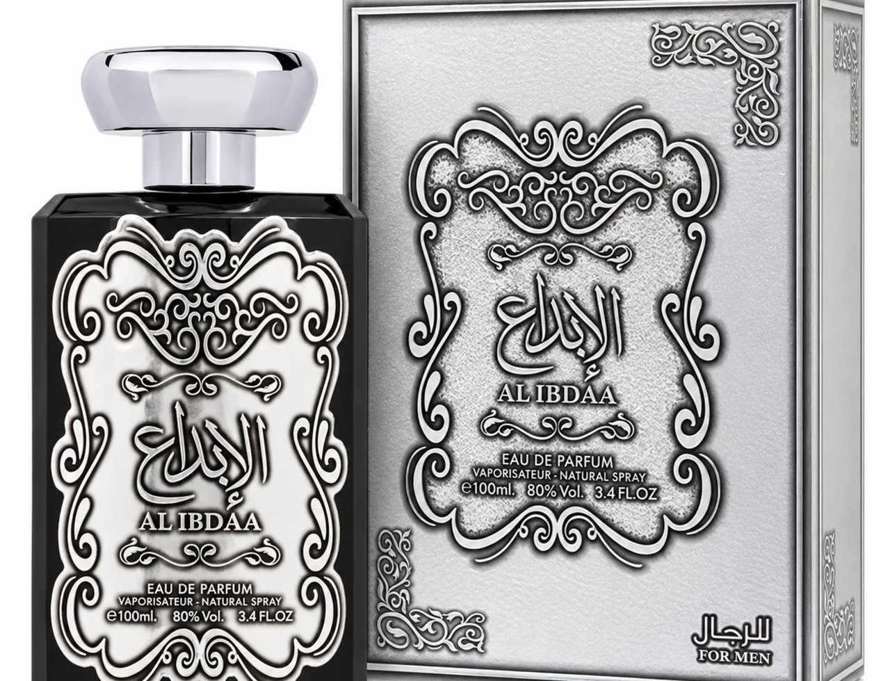 Ard Al Zaafaran Al Ibdaa Men Silver oleh Ard Al Zaafaran 100ml EDP Lelaki — Botol minyak wangi hitam berlabel perak berhias dan penutup perak, bersebelahan kotak peraknya dengan reka bentuk berhias yang sepadan.