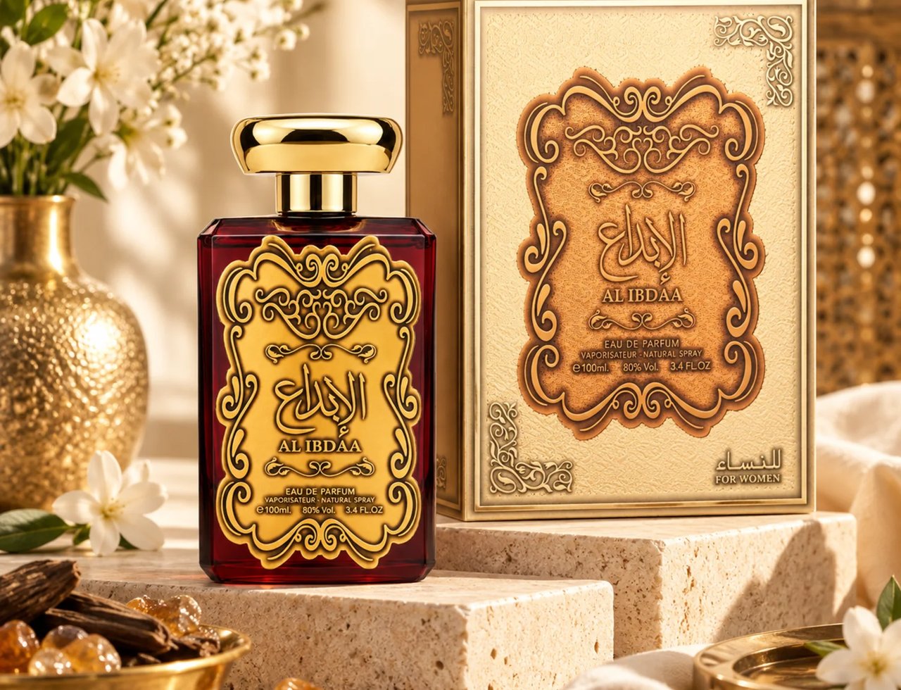 Ard Al Zaafaran Al Ibdaa Women Gold by Ard Al Zaafaran 100ml EDP Women — Botol minyak wangi kaca merah dengan label dan penutup emas berhias, pencahayaan studio.
