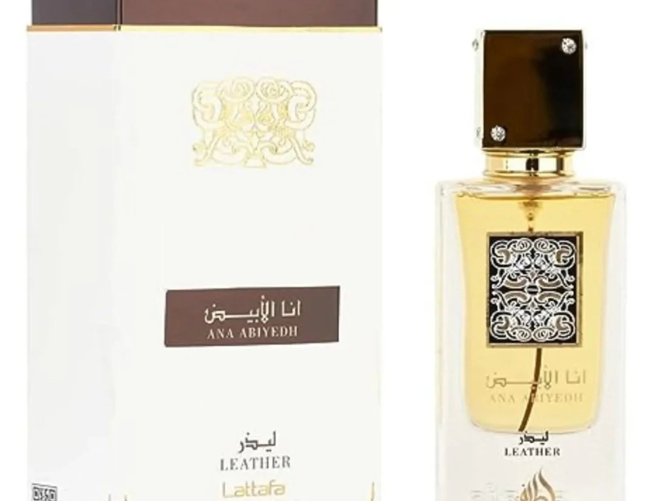 Lattafa Ana Abiyedh Leather 60ml by Lattafa Perfumes — A white perfume box with gold Arabic calligraphy and a clear glass bottle with gold accents and a dark cap, displayed side-by-side. | Lattafa Ana Abiyedh Leather 60ml by Lattafa Perfumes — Kotak minyak wangi putih dengan kaligrafi Arab emas dan botol kaca jernih